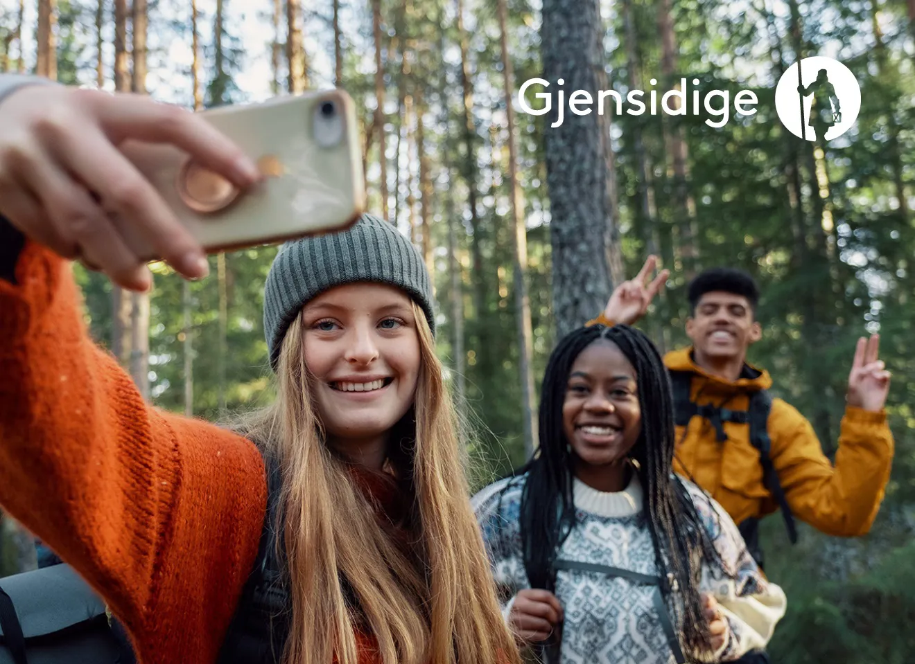 Tre unge personer i skogen ta selfie