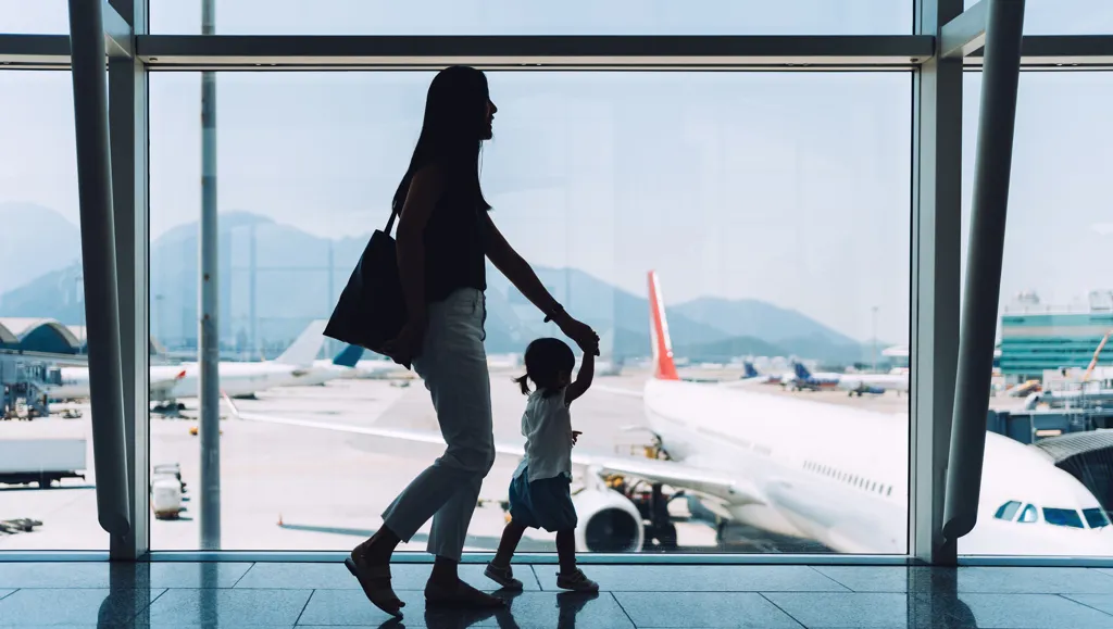 Siluett av forelder og barn på flyplass