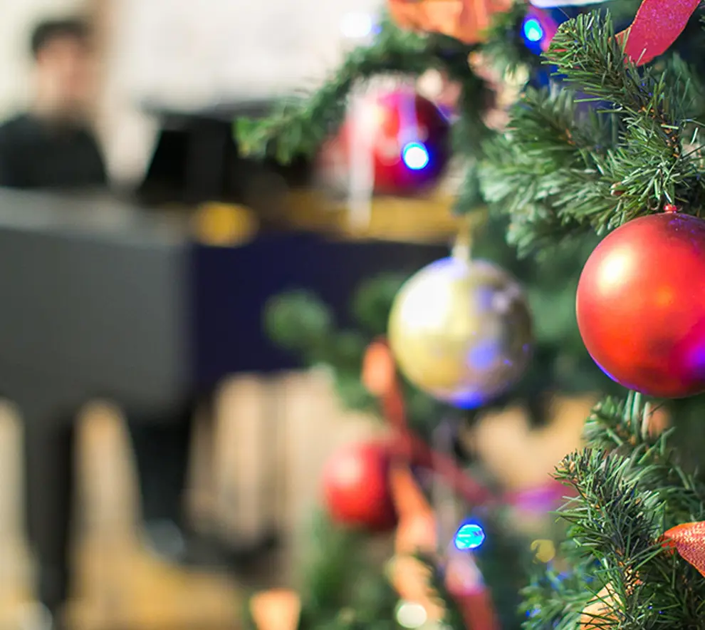 Julepynt og mann som spiller piano i bakgrunnen