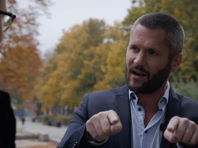 Niklas Modig står og snakker med en mann i en park