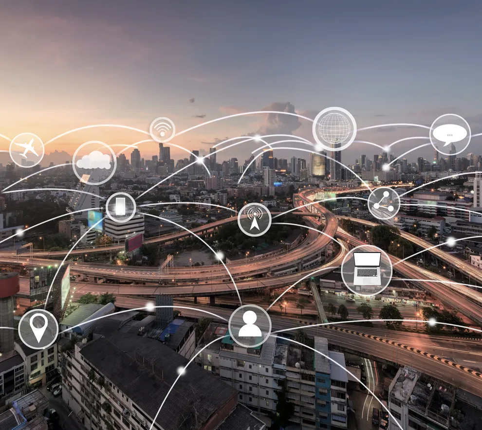 Illustrasjonsbilde av en stor by med motorvei hvor mange symboler og linjer er tegnet i luften over for å symbolisere internett og dataflyt