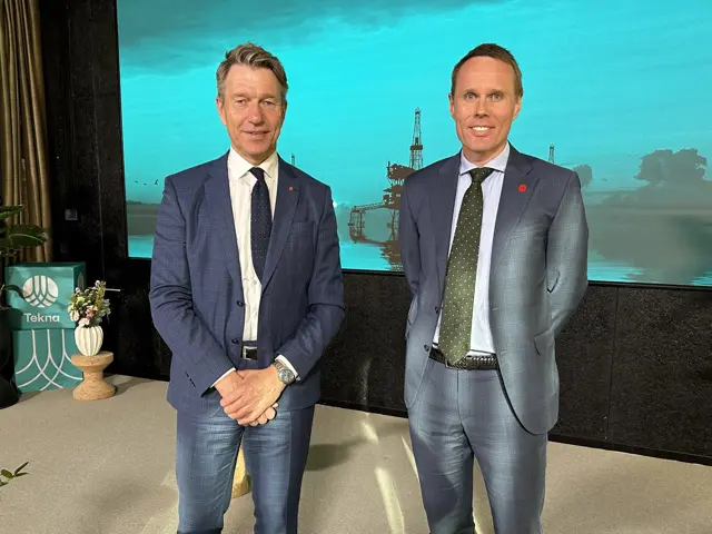 2 menn  i dress med Tekna-bakgrunn