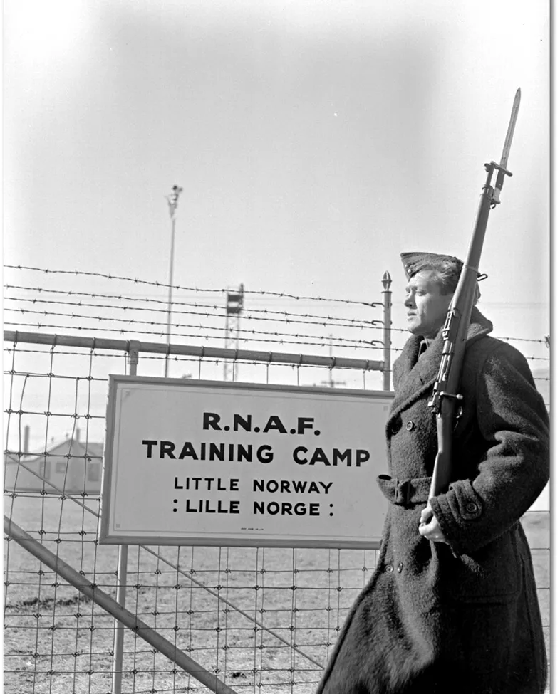 Soldat utenfor en militærleier med et skilt "Little Norway og Lille Norge"