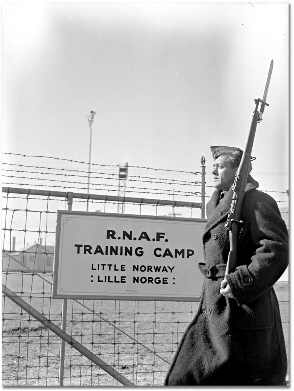 Soldat utenfor en militærleier med et skilt "Little Norway og Lille Norge"