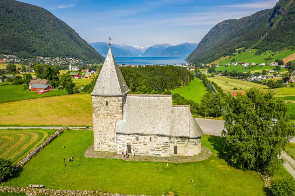 Et oversikt bilde av en steinkirke i norsk landskap