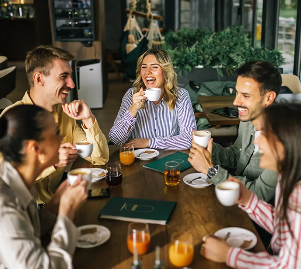 Unge venner som hygger seg rundt bordet