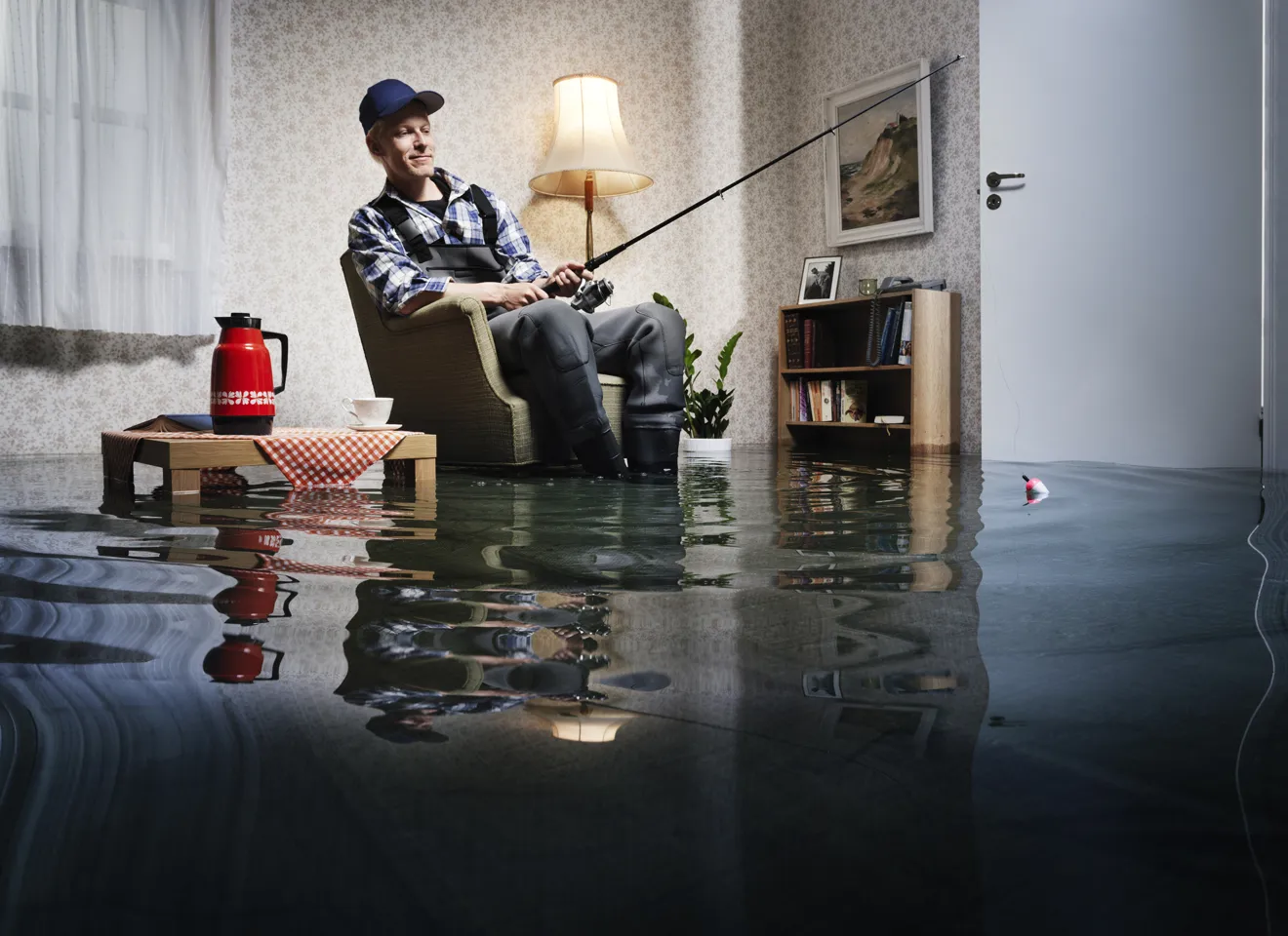 Illustrasjonsbilde av en mann som sitter i en oversvømmt stue og fisker