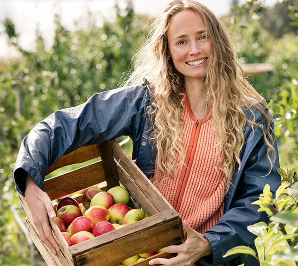 Kvinne på gård som holder epler