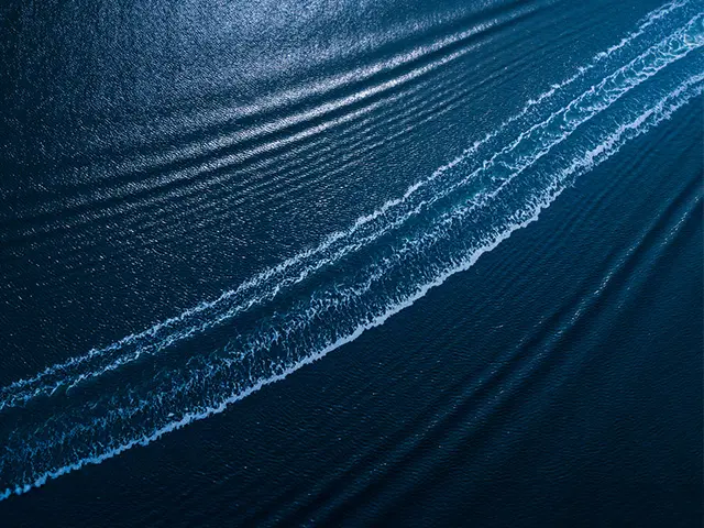 Hav, med bølger hvor en båt nylig har kjørt