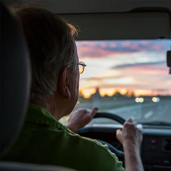 Eldre mann som kjører bil