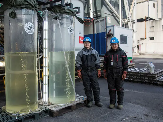 To kvinner i verneutstyr ved siden av to tanker