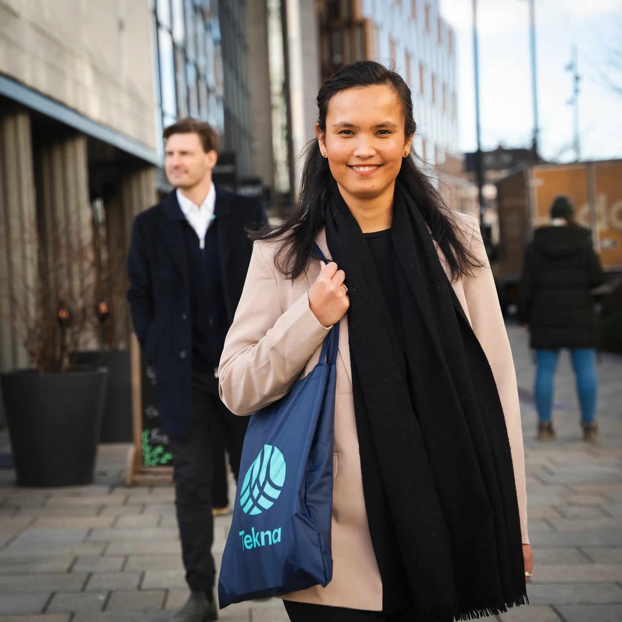 Kvinne med Tekna-veske og mann i bakgrunnen