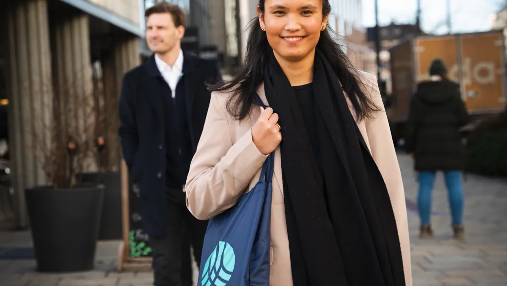 Kvinne med Tekna-veske og mann i bakgrunnen