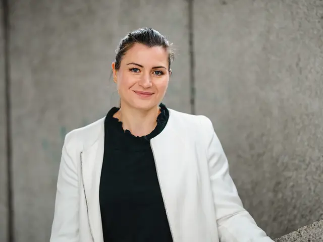 President Elisabet haugsbø med svart genser og hvit jakke, smiler 