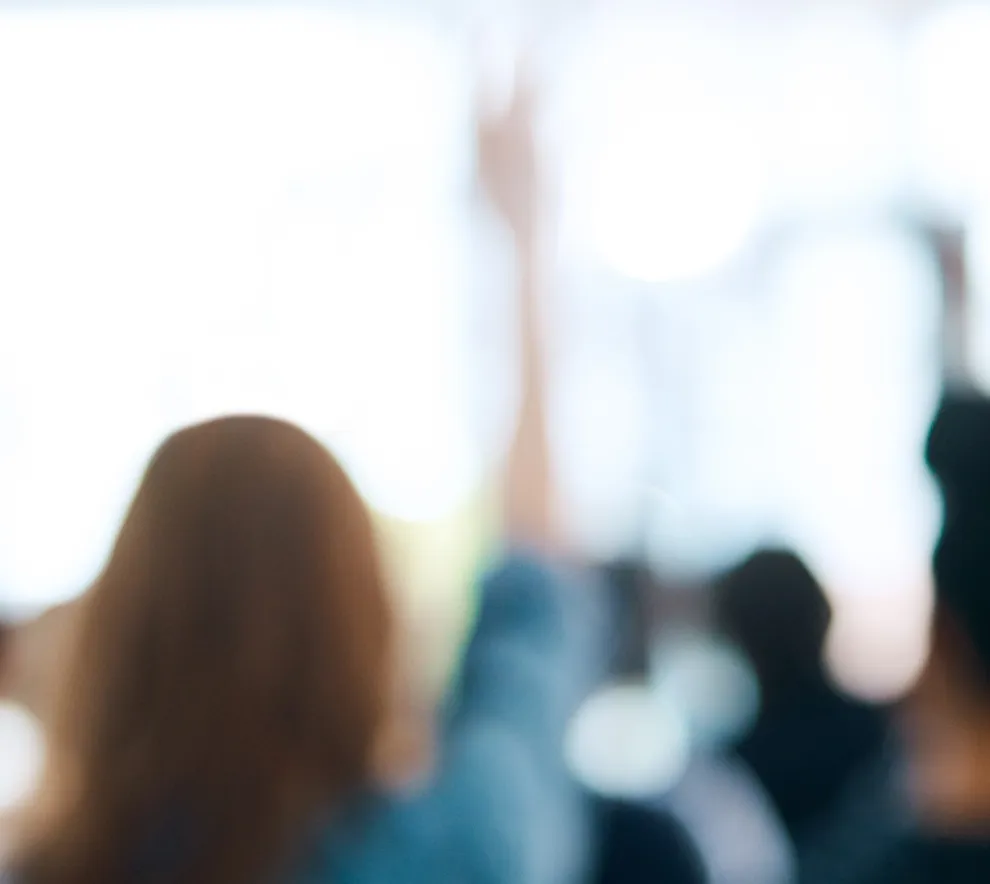 Illustrasjonsbilde av folk som rekker opp hender for å avstemme