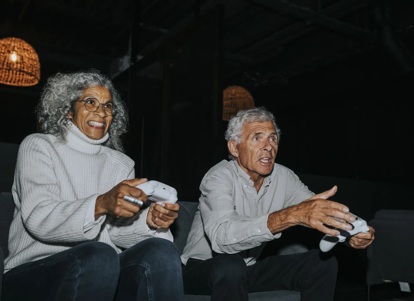 to eldre mennesker koser seg med  dataspill