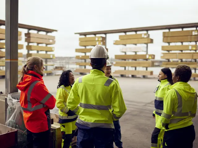 Bygningsarbeidere står og diskuterer