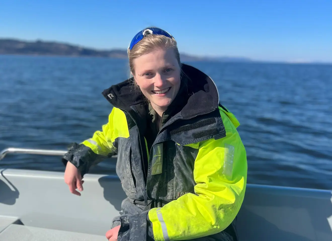 Kvinne sittende ved havet