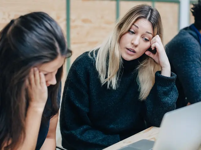 To trøtte unge kvinner som prøver å studere sammen