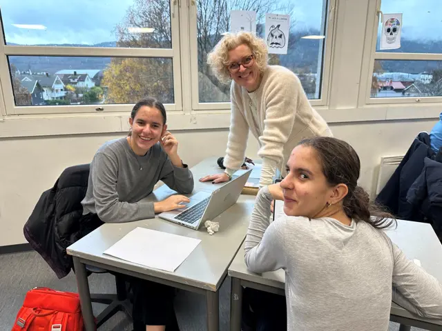 Lærer og 2 elever mot vindu bak