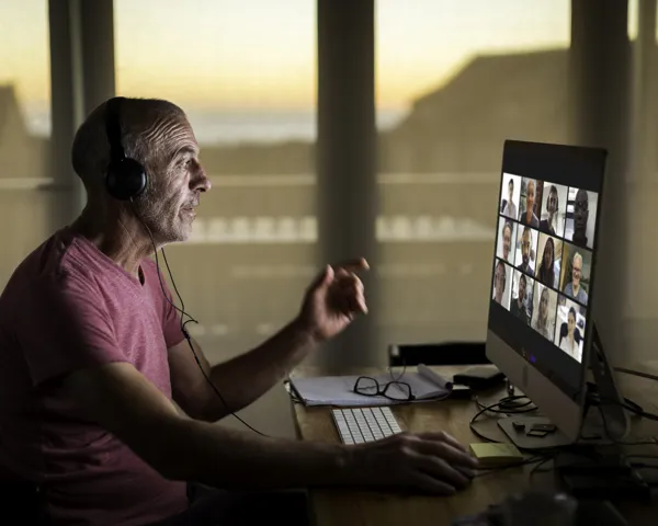 Eldre mann foran iMac med videomøte