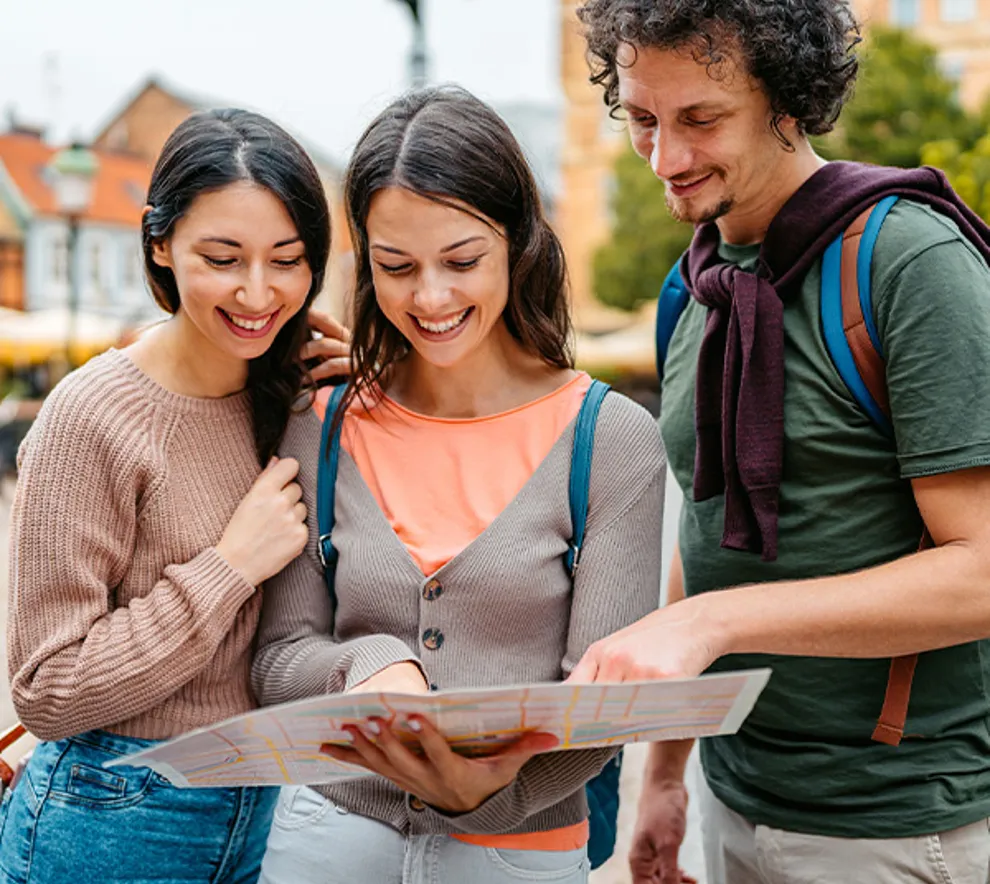 Tre venner som ser på kart