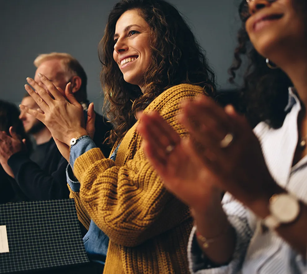 Mennesker på et møte som klapper