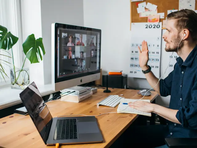Illustrasjonsbilde av en mann på hjemmekontor med videosamtale med en gruppe mennesker