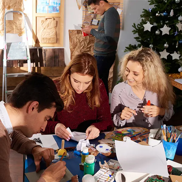Tre voksne som lager juledekorasjoner