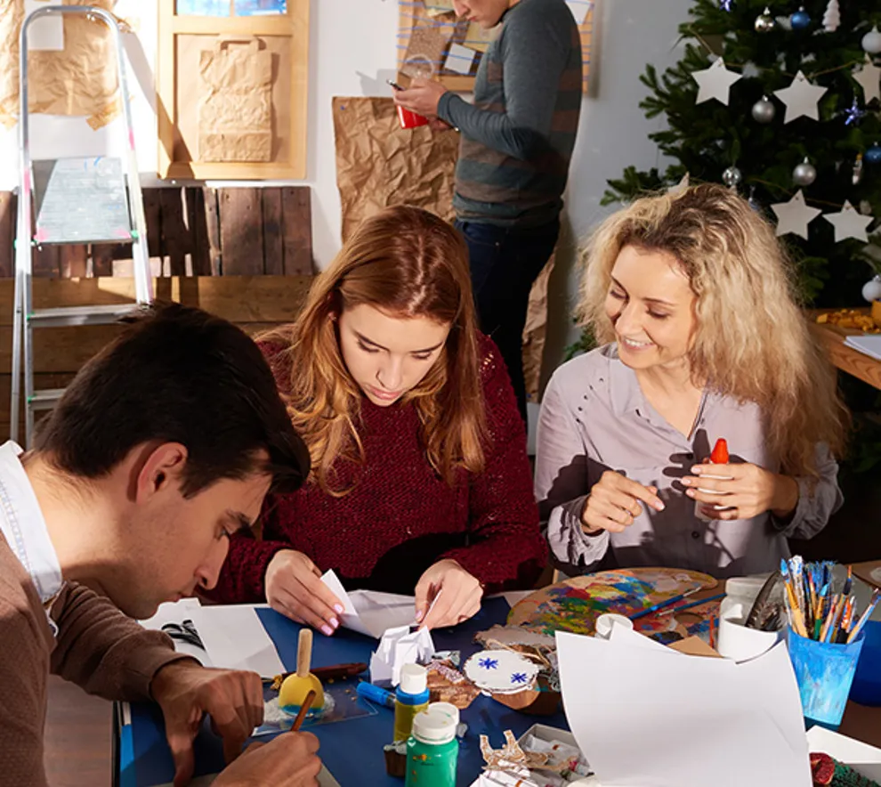 Tre voksne som lager juledekorasjoner