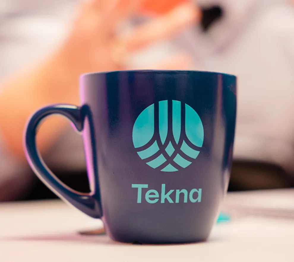 Kaffekopp med Tekna-logo på bord