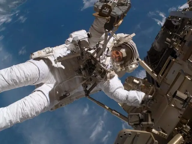 Astronaut i verdensrommet med jorden i bakgrunn