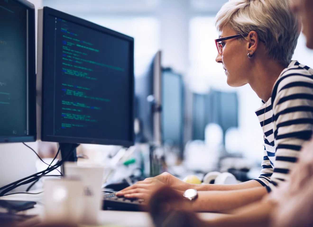 Kvinne på jobb sitter foran skjerm med koder