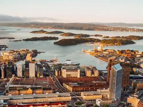 Flyfoto av Oslo sentrum og havn med byen nærmest og havet med øyer i bakgrunnen