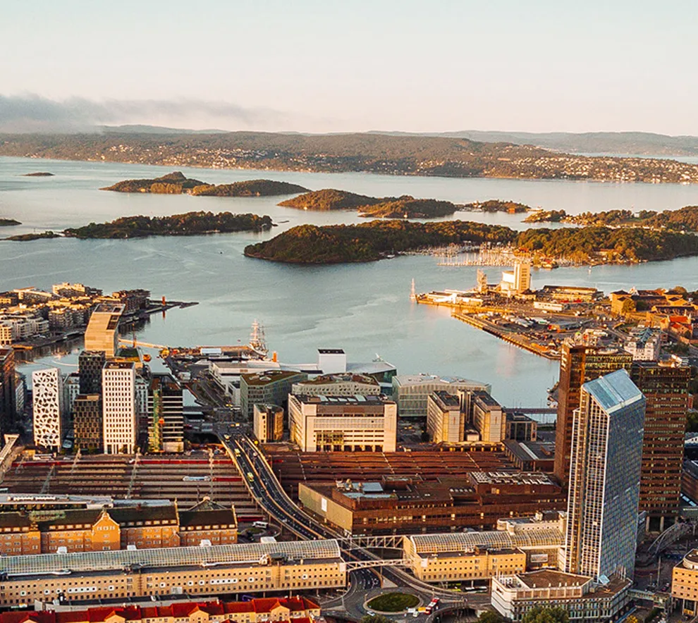 Flyfoto av Oslo sentrum og havn med byen nærmest og havet med øyer i bakgrunnen