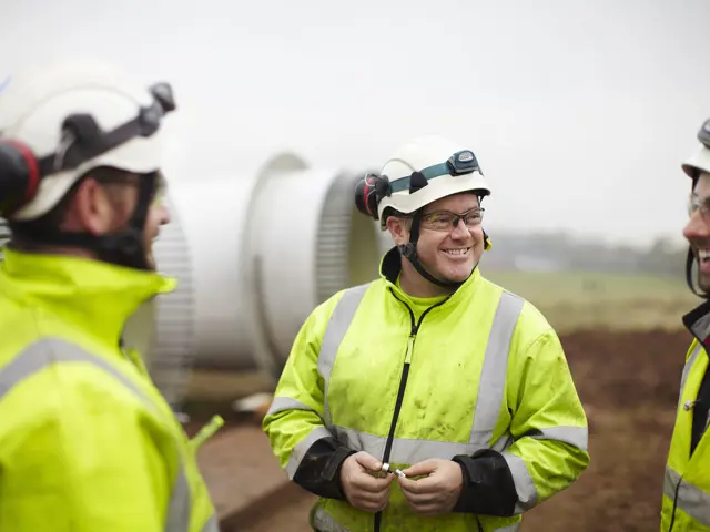 Arbeidere i verneutstyr se på hverandre og smiler