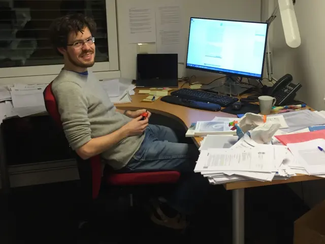 Borgar Aamaas smiler til kamera sittende foran et rotete kontorbord om kveldstid