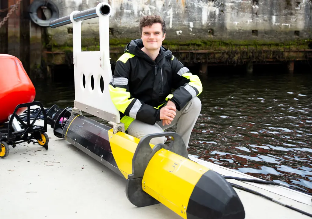 Mann m gul bøye på flytebrygge