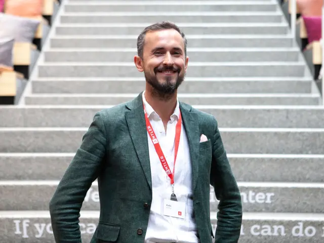 Mann i dress står i trapp