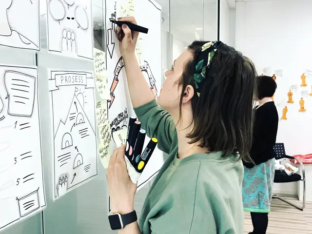 Ung kvinne skriver på en whiteboard