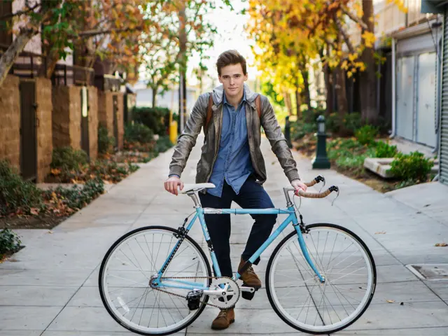 Ung mann poserer med en stilren bukkehornssykkel