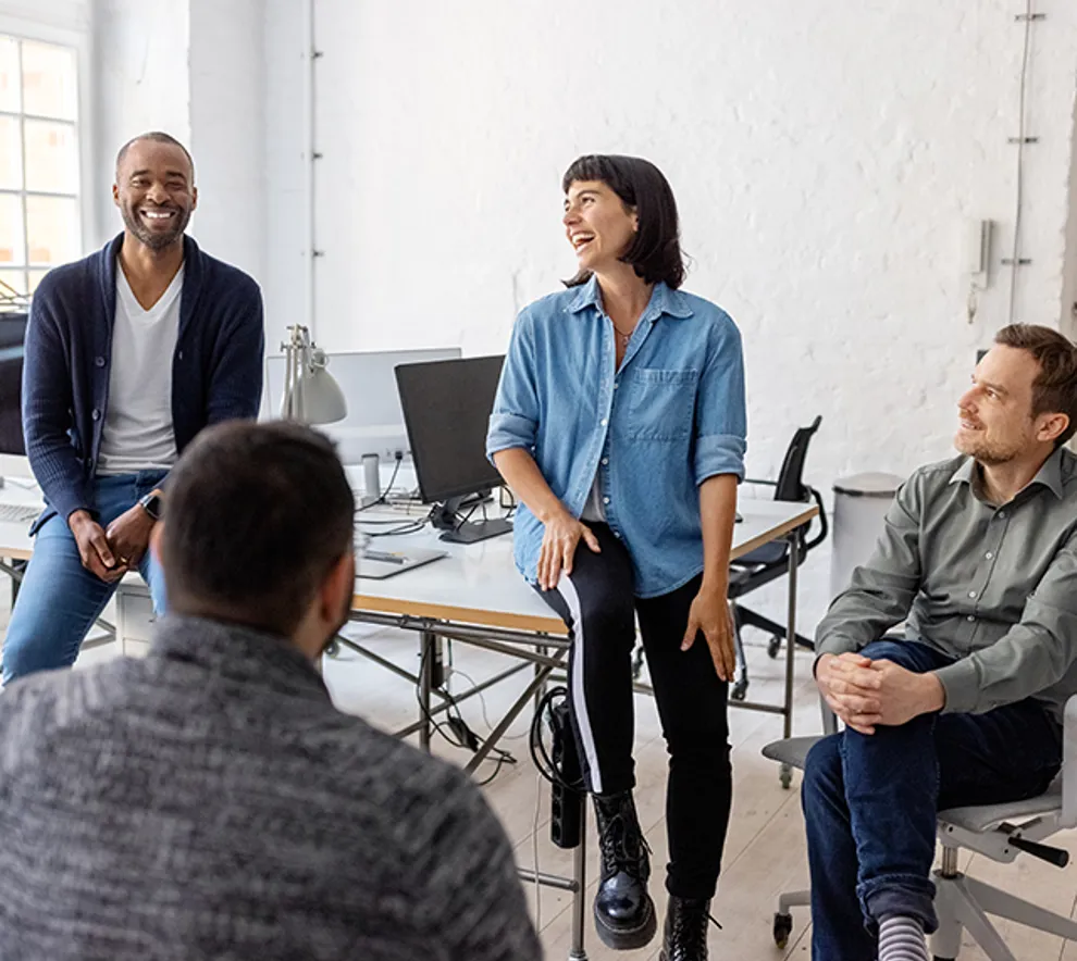 Kollegaer som sitter samlet og har det hyggelig