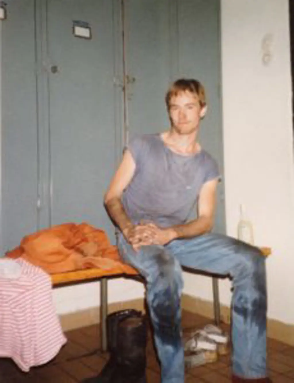Øystein Rushfeldt i et gulnet fotografi, han har på seg kortermet skjorte og tilsølte jeans. Underarmene er mørke av skitt. 