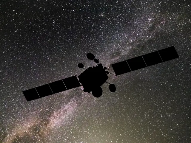 Mørk satelitt med stjernehimmel i bakgrunnen