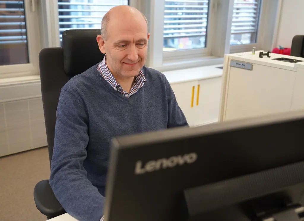 Anders Kvam på kontoret foran en PC