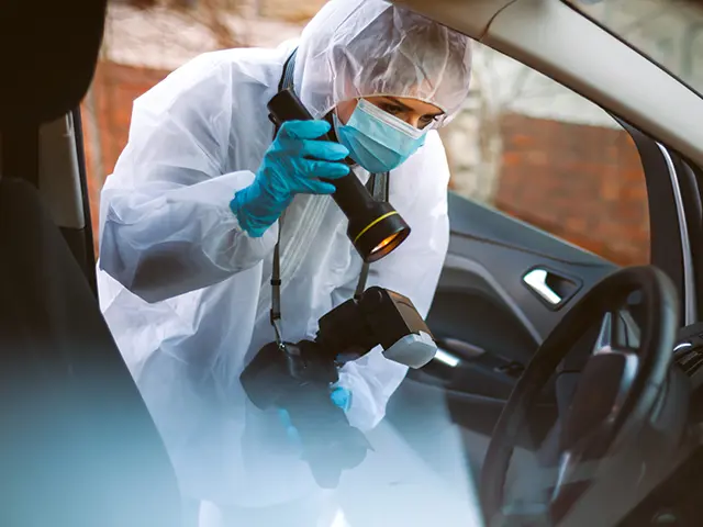 Kriminaltekniker i arbeid med bilder i en bil