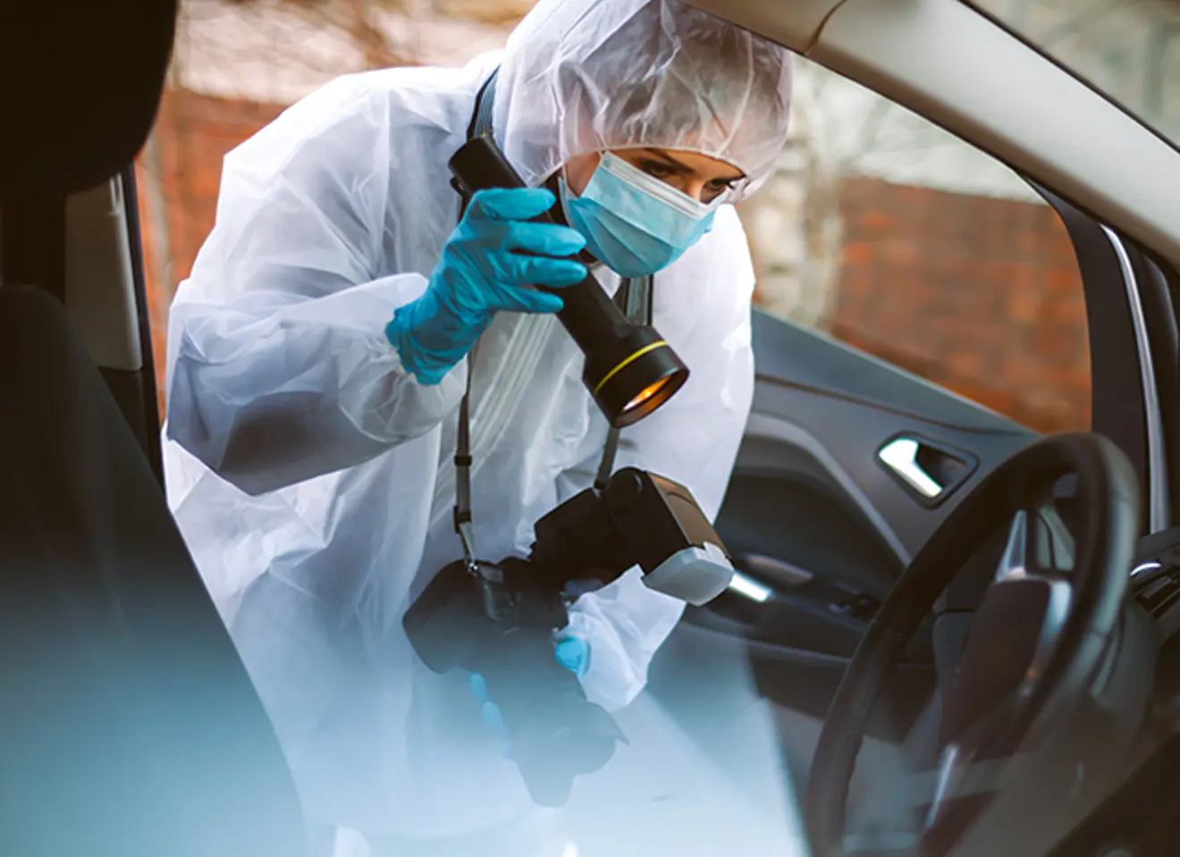 Kriminaltekniker i arbeid med bilder i en bil