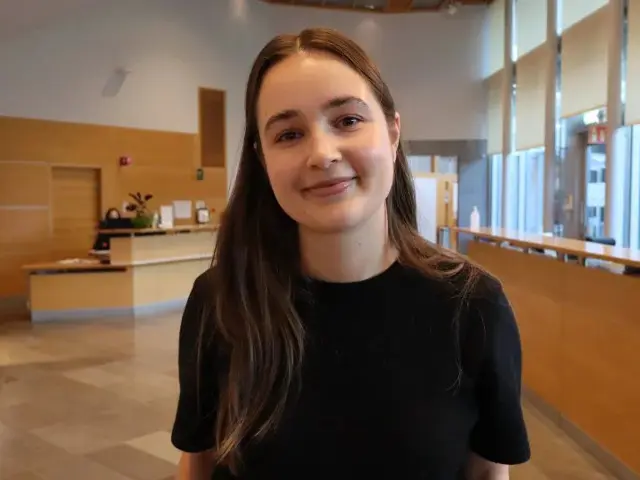 Kvinne ser inn i kamera