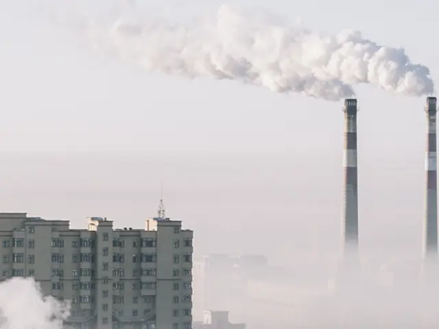 industripiper spyr ut røyk over by