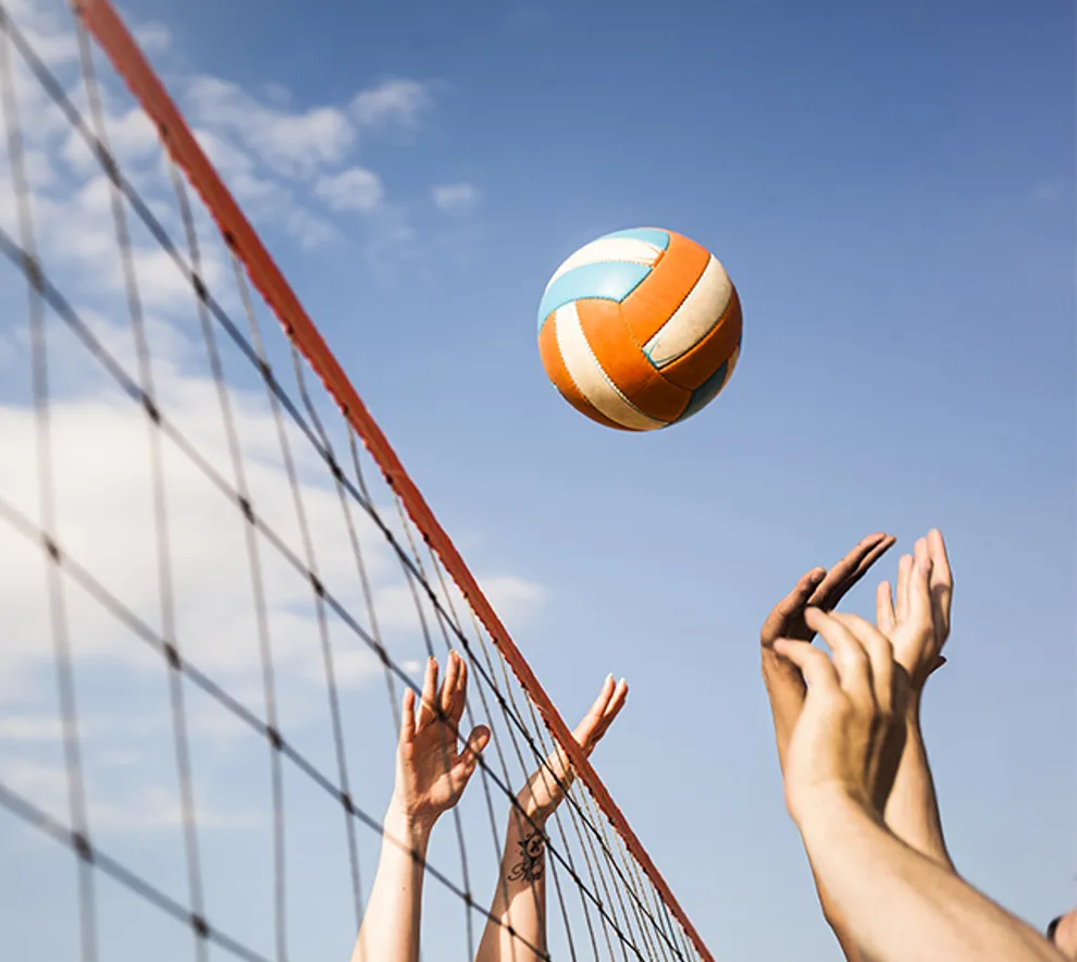 Volleyballnett, ball og to par hender